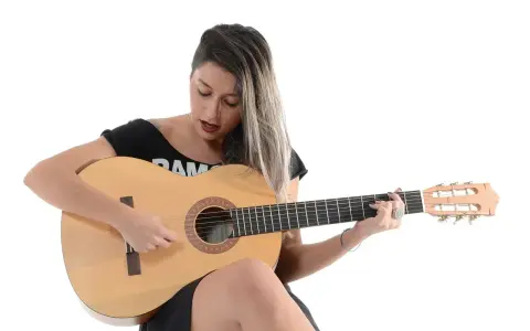 Kobieta gra na gitarze, nucąc stare piosenki country.