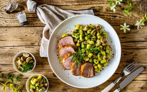 Saftige schweinelende grillen, serviert mit Kartoffeln und Pilzen, garniert mit frischer Petersilie. Ein Genuss für jeden Grillmeister!