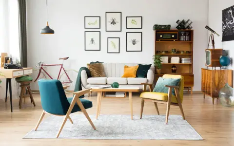 Wohnzimmer im 60er Jahre Style mit Retro-Möbeln, einem Fahrrad und Insektenbildern an der Wand.