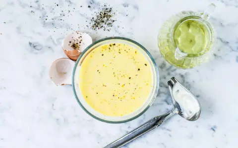 Zutaten für eine cremige french dressing: Eierschalen, Pfeffer, Öl und eine Schüssel mit der fertigen Soße.