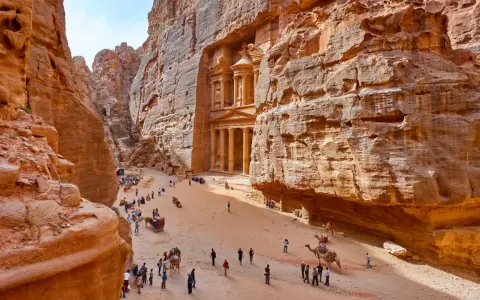 Skaliste wąwozy Petry, Jordania. Wspaniałe widoki, idealne na jordania loty. Turyści i wielbłądy w drodze do Skarbca.