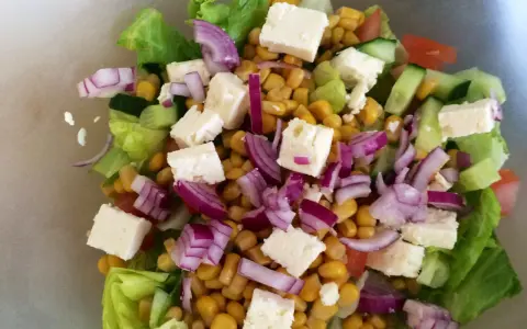 En fräsch sallad med sallad, majs, fetaost, rödlök och gurka. Perfekt för ett lätt och näringsrikt deffa kostschema.