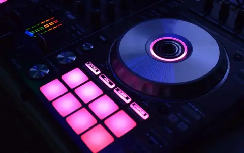 DJ kontroler z podświetlanymi na różowo padami i świecącym na niebiesko talerzem. Idealny do tworzenia muzyki, np. dubstep co to za gatunek?