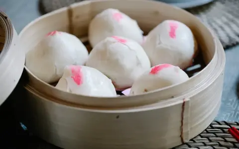 Pierożki baozi w bambusowym parowniku, gotowe do podania.