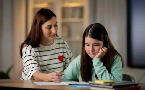 Mama tłumaczy córce, jak działa edukacja domowa. Dziewczynka zamyślona, opiera głowę na dłoni.