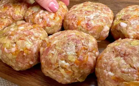 Mani che preparano polpette in bianco, un impasto di carne macinata con verdure, pronte per essere cucinate.