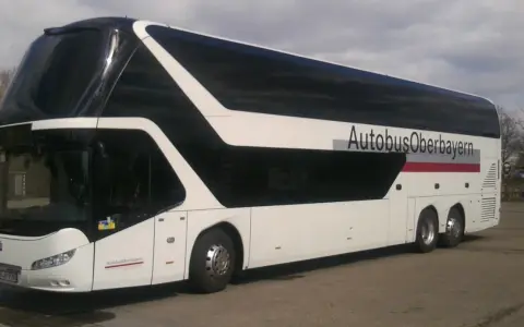 Biały autokar piętrowy z czarnymi oknami i napisem "AutobusOberbayern".