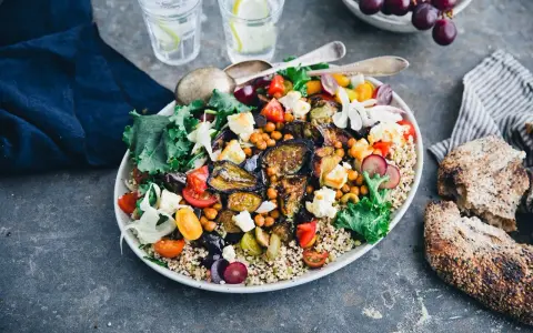 En härlig bowl med quinoa, kikärtor, tomater, fetaost och härligt grillad aubergine. Serveras med gott bröd och vatten med citron.