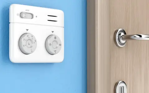 Termostato bianco su muro blu, parte di sistemi termoregolazione evoluti per un comfort ottimale. Manopole per impostare la temperatura.