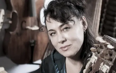 Maria Pomianowska z fidelą i instrumentami smyczkowymi w tle.