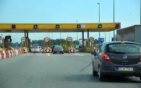 Bramki autostrady A1 z samochodami zbliżającymi się do punktu poboru opłat.
