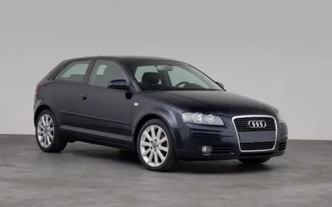 Dunkelblauer Audi A3 1.9 TDI Dreitürer steht auf grauem Boden vor hellem Hintergrund.