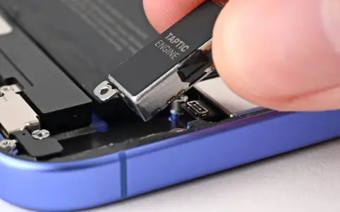 Dłoń wyjmuje moduł Taptic Engine z wnętrza telefonu, element odpowiedzialny za zaawansowane wibracje i 3D Touch.