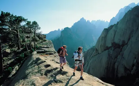 Zwei Wanderer auf dem korsika weitwanderweg genießen die atemberaubende Berglandschaft.