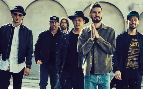 Sechs Männer der Band Linkin Park stehen nebeneinander, einige tragen Hüte und Jacken.
