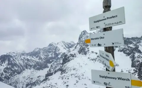 Szpiglasowy Wierch od Morskiego Oka. Znak szlaku w zimowych Tatrach wskazuje drogę na szczyt.