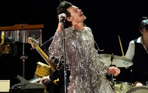 Harry Styles i sin glittriga outfit på scen i Stockholm, sjungandes med passion.
