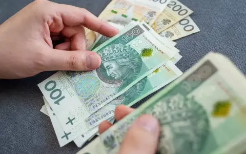 Dłonie liczą polskie banknoty 100 zł. Temat: zespół Aspergera a renta socjalna.