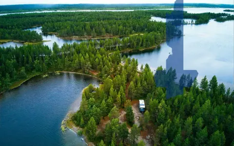 Ein Wohnmobil steht am Ufer eines Sees inmitten dichter Wälder. Perfekt für wildcampen Finnland!