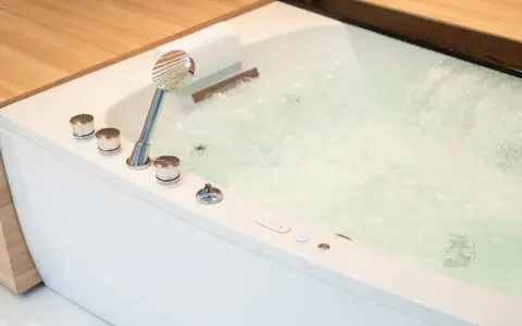 Bain bouillonnant avec jets d'eau et douchette chromée, prêt pour un moment de détente dans ce spa balnéo.