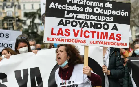 Manifestantes protestan contra la ocupación de vivienda habitual. Una mujer grita, portando un cartel que apoya a las víctimas de #Leyantiocupas.
