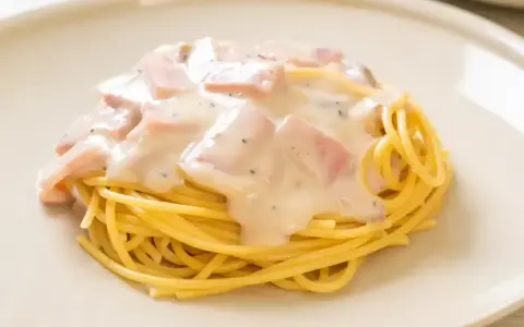 Pyszne spaghetti z kremowym sosem, kawałkami szynki i pieprzem. Idealne makaron po toskańsku na szybki obiad.