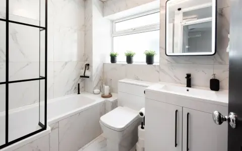 Elegantes azulejos de mármol blanco y negro para un baño pequeño. Ideas para un baño moderno y funcional.