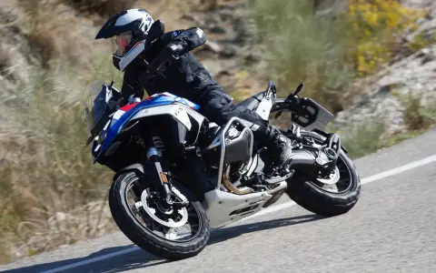 Motociclista in sella a una BMW GS 1300, che affronta una curva su strada sterrata, sfiorando la velocità massima.