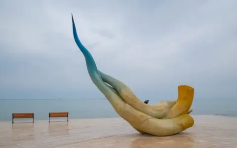 Rzeźba na promenadzie w Durrës, idealne miejsce, by zobaczyć zachód słońca. Dwie ławki czekają na spacerowiczów.