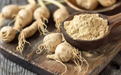 Korzeń maca i proszek na drewnianej desce. Odkryj niezwykłe maca właściwości tego superfoods, cenionego za energię i witalność.
