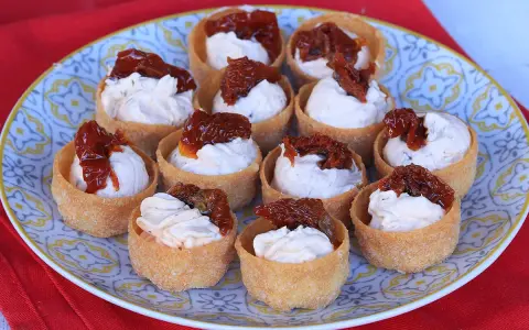 Antipasti veloci ed economici senza cottura: cestini croccanti ripieni di crema e pomodori secchi.
