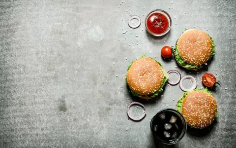 Tre saftiga hamburgare, en skål med ketchup, tomater, rödlök och en läsk med is. Perfekt för en mysig kväll på vår western grillhouse.