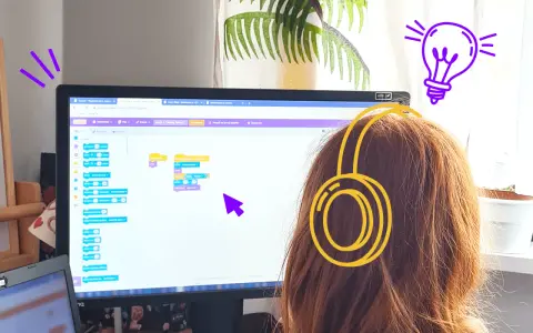 Dziewczynka w słuchawkach tworzy kod w Scratch po polsku, ucząc się programowania.