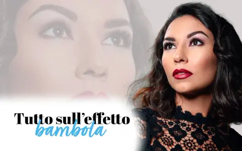 Un trucco per ciglia che dona uno sguardo da bambola. Labbra rosse e un abito di pizzo completano il look.