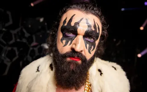 Hank von Hell med dramatisk smink, skägg och en pälskrage.