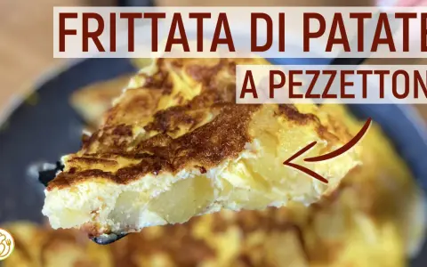 Una fetta di frittata di patate dorata e soffice, con patate a pezzettoni ben visibili all'interno.