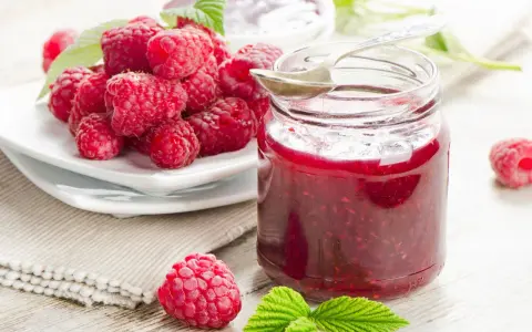 Frische Himbeeren und ein Glas selbstgemachte Himbeermarmelade. Ein einfaches Rezept für den Sommer.