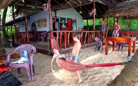 Niños disfrutan de una hamaca en una playa de Sri Lanka. Un paraíso tropical para familias.
