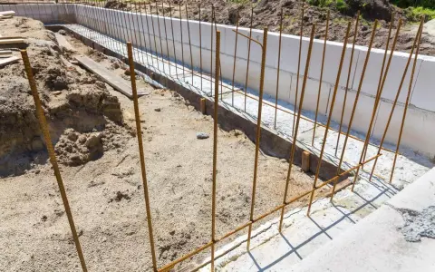 Zbrojenie fundamentu w trakcie budowy, stalowe pręty tworzą ruszt dla przyszłego betonu.