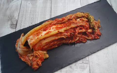 Frisch zubereitetes Kimchi, das beste Kimchi Rezept, liegt auf einem schwarzen Stein.