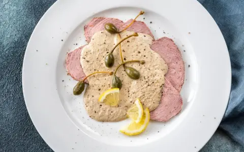 Dünne Scheiben Kalbfleisch mit cremiger Thunfischsauce, Kapern und Zitronenspalten – das beste Vitello Tonnato Rezept für einen Genussmoment.