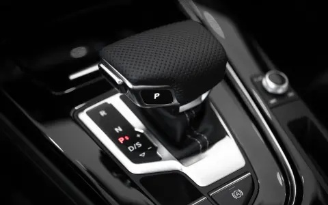 Skórzana gałka zmiany biegów z przyciskiem "P" i oznaczeniami R, N, P, D/S. Elegancki element wnętrza samochodu z technologią tiptronic.