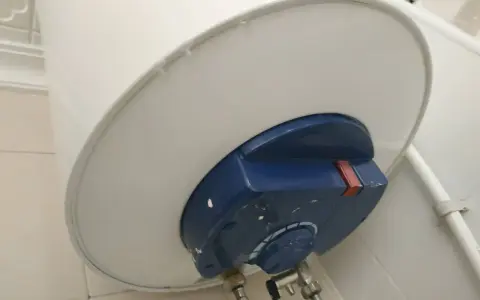 El termo gotea por abajo, mostrando una fuga de agua en la parte inferior del calentador.