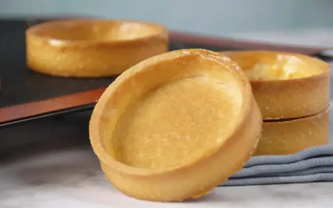Fonds de tartelettes dorés, prêts pour une recette de pâte sucrée. Parfaits pour des desserts gourmands.