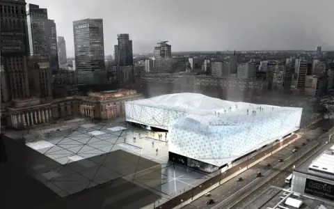 Nowoczesny budynek muzeum sztuki współczesnej w Warszawie, z charakterystyczną, geometryczną fasadą, otoczony placem i otoczeniem miejskim.