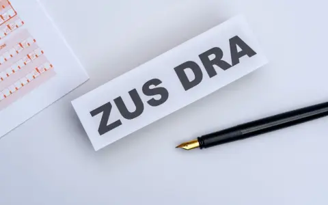 ZUS DRA na papierze, obok czarne pióro. Dokumenty do wypełnienia.