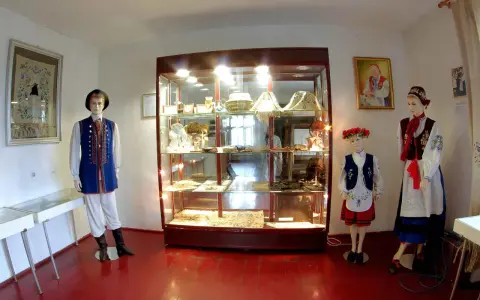 W muzeum kaszubskim prezentowane są tradycyjne stroje i rękodzieło. Manekiny w ludowych strojach stoją obok gablot z eksponatami.