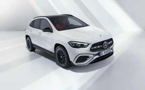 La nuova GLA 2026, un SUV bianco con tetto nero e interni rossi, si presenta in uno studio minimalista.