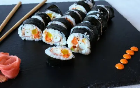 Roladki sushi z surimi, marchewką i papryką. Czy surimi jest zdrowe? Zależy od składu i sposobu przygotowania.