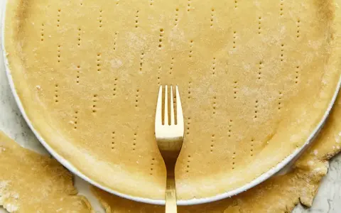Une pâte brisée sans beurre, piquée à la fourchette, prête à être garnie.